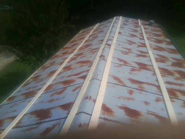 Rusted metal roof panels with new wood purlins before replacement — Storm Damage Roof Repair in Peru by Roofing Brothers